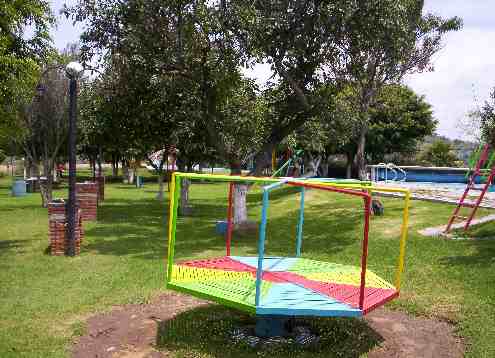 Fotografiá de la zona del jardín de juegos, se enfoca a una pirinola.